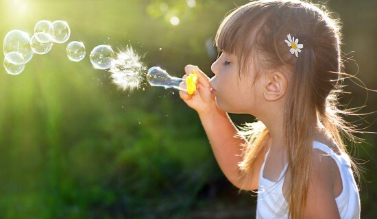 Little girl blowing soap bubbles