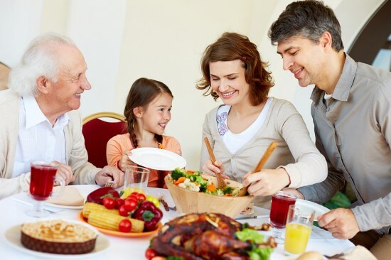 Portrait of happy family sitting at festive table while having T