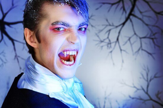 Portrait of a handsome young man with vampire style make-up. Sho